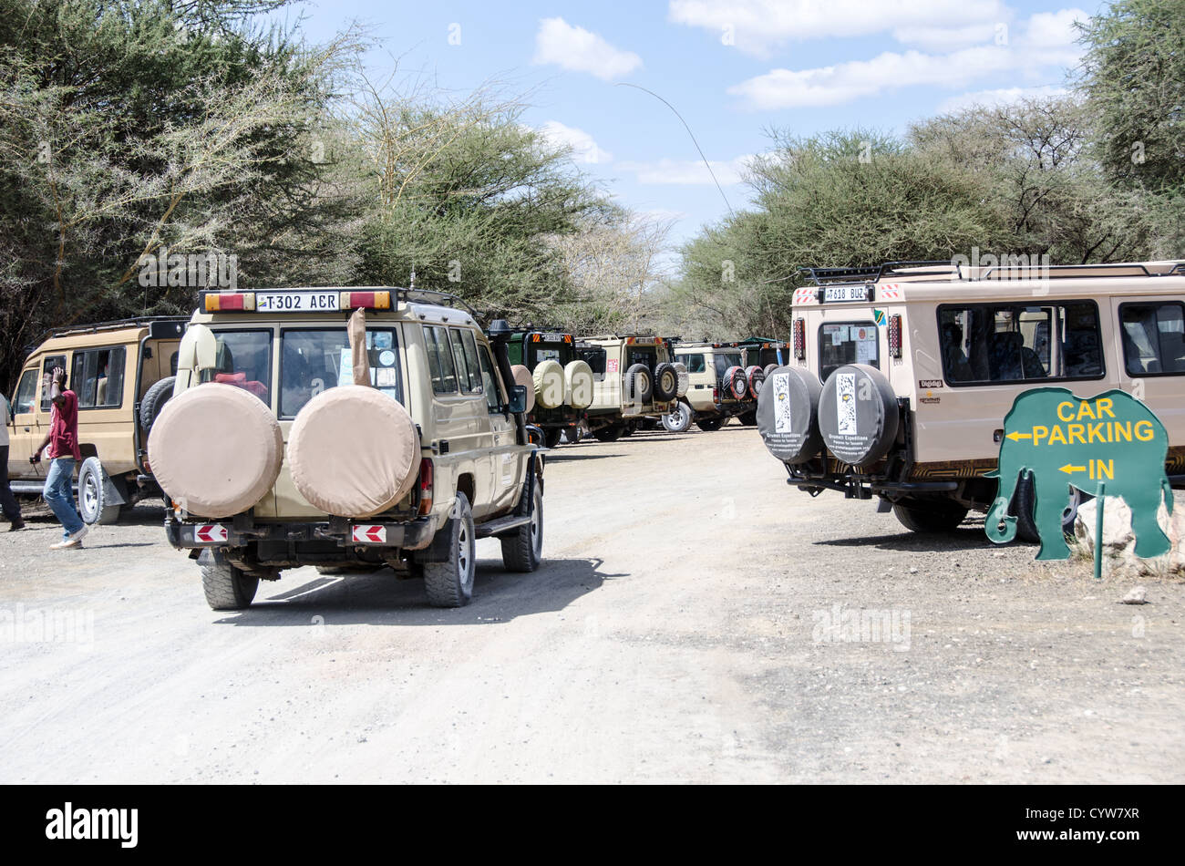 TARANGIRE-NATIONALPARK, Tansania - Safarifahrzeuge stehen auf dem Parkplatz am Haupteingang des Tarangire-Nationalparks im Norden Tansanias, nicht weit vom Ngorongoro-Krater und der Serengeti. Der Ngorongoro-Krater, der zum UNESCO-Weltkulturerbe gehört, ist ein riesiger vulkanischer Krater im Norden Tansanias. Sie wurde vor 2-3 Millionen Jahren gegründet, hat einen Durchmesser von etwa 20 Kilometern und ist die Heimat vielfältiger Tiere, einschließlich der „Big Five“-Wildtiere. Das Ngorongoro Conservation Area, das von den Maasai bewohnt wird, enthält auch bedeutende archäologische Stätten wie die Olduvai-Schlucht und Laetoli, die o Stockfoto