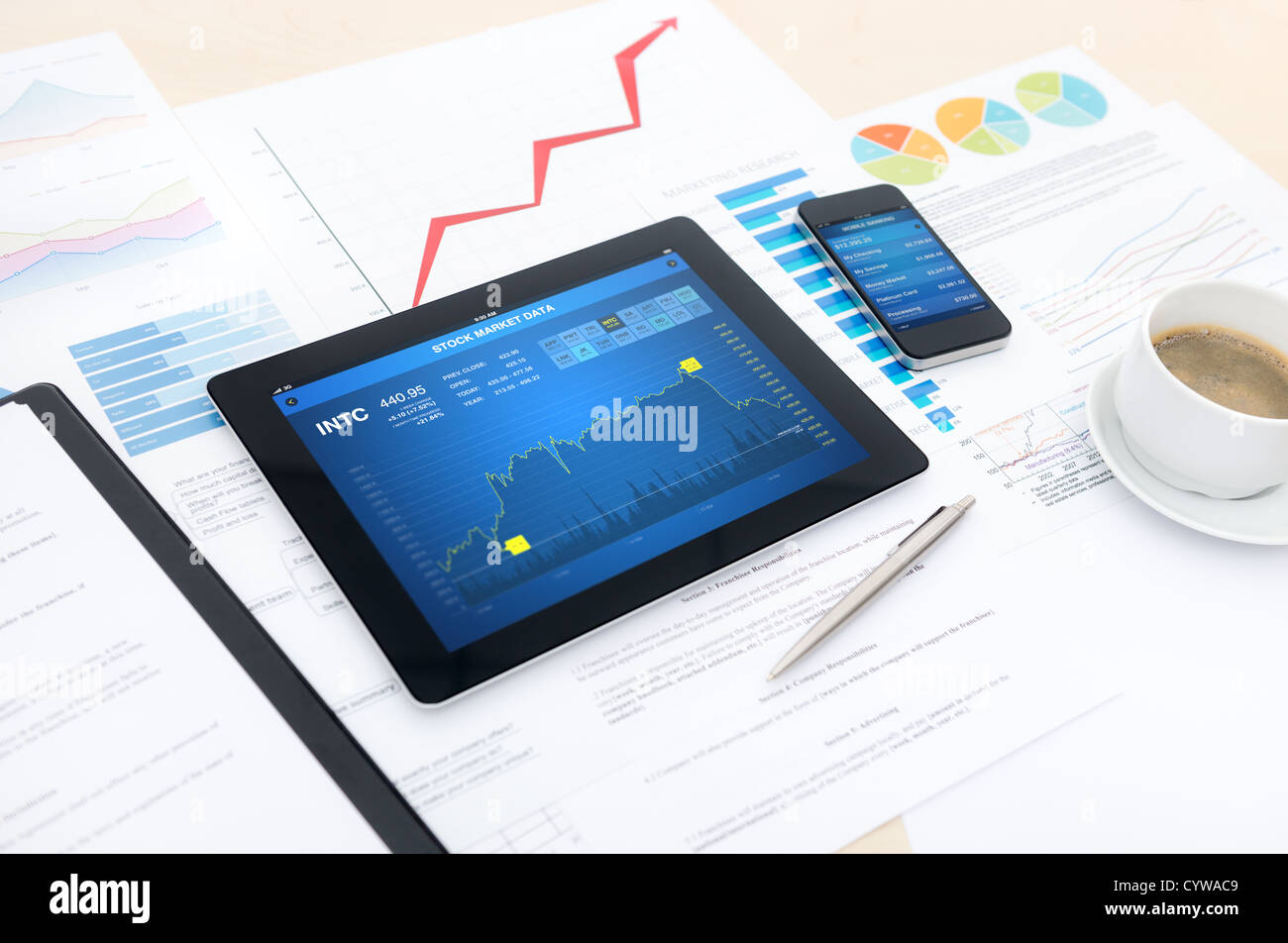 Moderne Business-Arbeitsplatz mit Börsendaten, mobile Banking, einige Diagramme und Grafiken auf dem Schreibtisch. Stockfoto