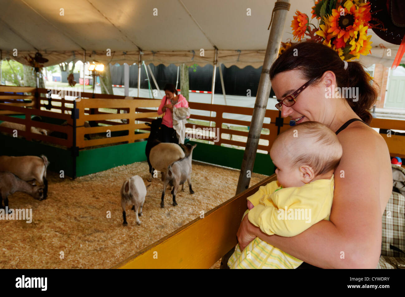 Eine Mutter zeigt ihr Baby die Ziegen im Streichelzoo Stockfoto