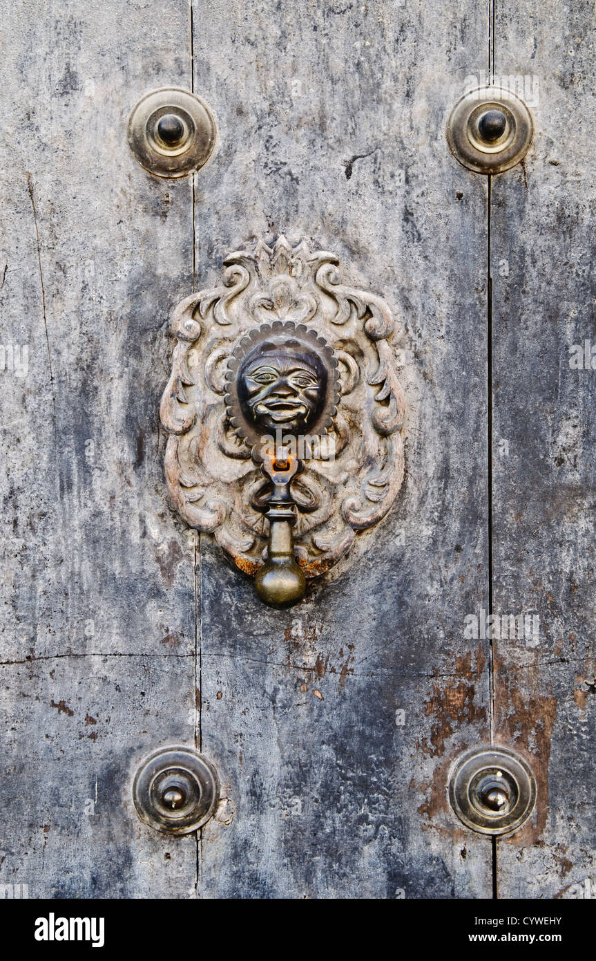 Holzklopfer Antigua Guatemala // ANTIGUA GUATEMALA, Guatemala — ein kunstvoller hölzerner Türklopfer ziert eine traditionelle Tür in Antigua Guatemala, das 1979 zum UNESCO-Weltkulturerbe ernannt wurde. Die Kolonialstadt, die Anfang des 16. Jahrhunderts als Santiago de Guatemala gegründet wurde, diente mehr als 200 Jahre lang als Hauptstadt Guatemalas, bis die verheerenden Erdbeben 1773 die Beamten dazu veranlassten, die Hauptstadt zu verlegen. Antigua ist bekannt für seine gut erhaltene, vom spanischen Barock beeinflusste Architektur und zahlreiche teilweise restaurierte Ruinen, die von der seismischen Aktivität zeugen, die das regio geprägt hat Stockfoto