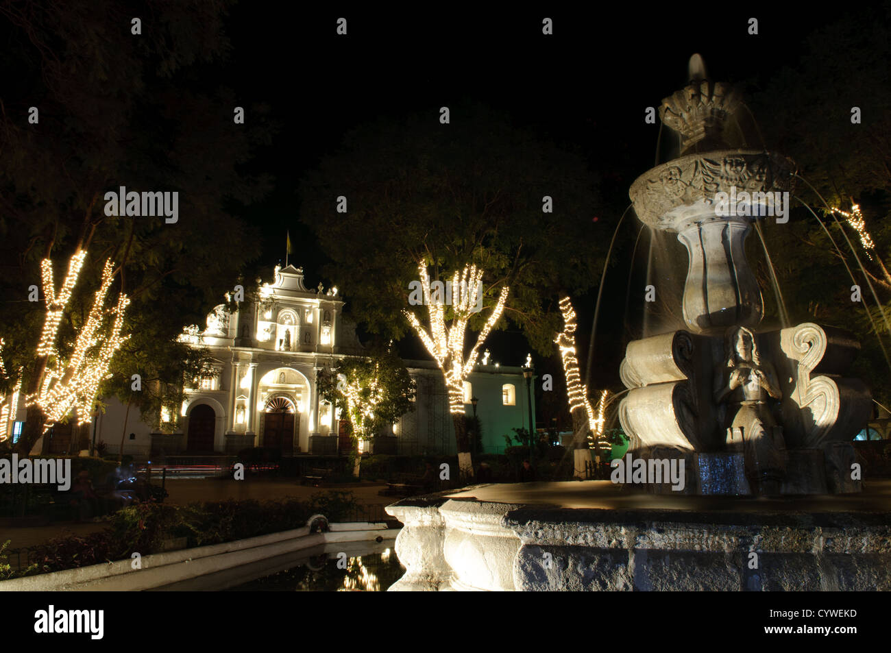 ANTIGUA GUATEMALA, Guatemala – Lichterketten sind um die Bäume auf dem zentralen Stadtplatz in Antigua Guatemala gewickelt. Antigua Guatemala ist berühmt für seine gut erhaltene spanische Barockarchitektur sowie eine Reihe von Erdbebenruinen und gehört zum UNESCO-Weltkulturerbe und ehemalige Hauptstadt Guatemalas. Stockfoto