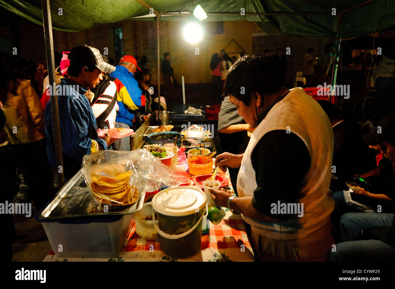 ANTIGUA, Guatemala - Abendessen in einem Street Food vendor als Teil einer Nacht Markt für den Urlaub Unserer Lieben Frau von Guadalupe Tag in Antigua, Guatemala. Stockfoto