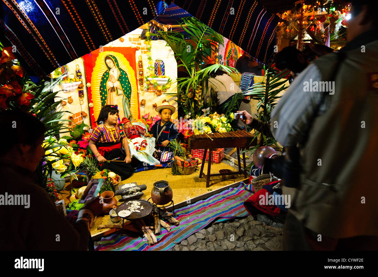 Zwei Kinder in Anitgua, Guatemala, posieren für Fotos im Kostüm mit einer traditionellen Szene im Hintergrund. Dies war Teil eines Marktes in der Innenstadt von Antigua in der Feier der ein nationaler Feiertag. Stockfoto