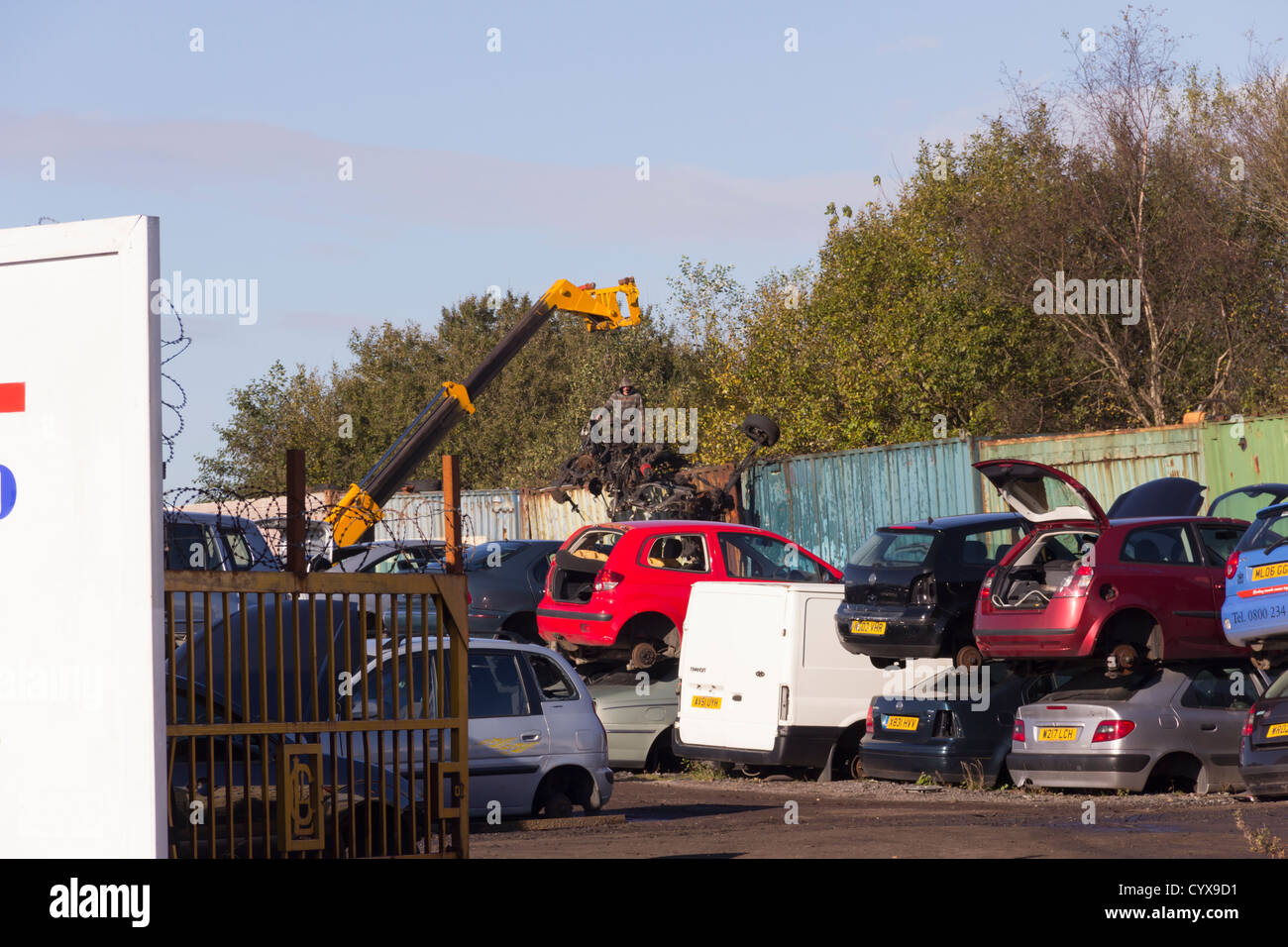 J Campbell Auto Schrotthändler und recycling-Anlage in Waterloo Street, Bolton. Ein kleiner mobiler Kran hebt Schrottteilen. Stockfoto