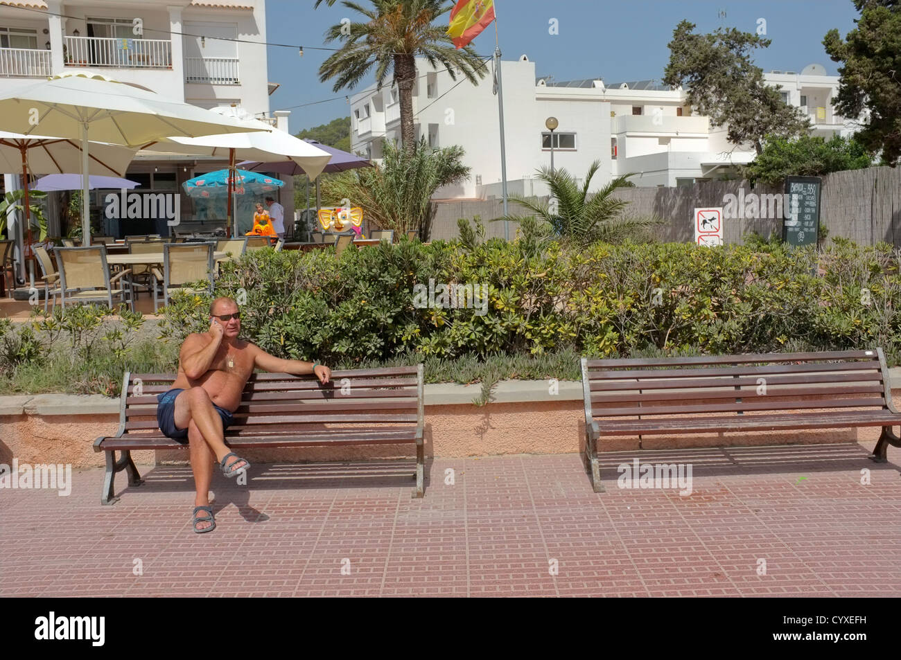 Ein Urlauber in Calla Llonga, Ibiza mit seinem Handy. Stockfoto