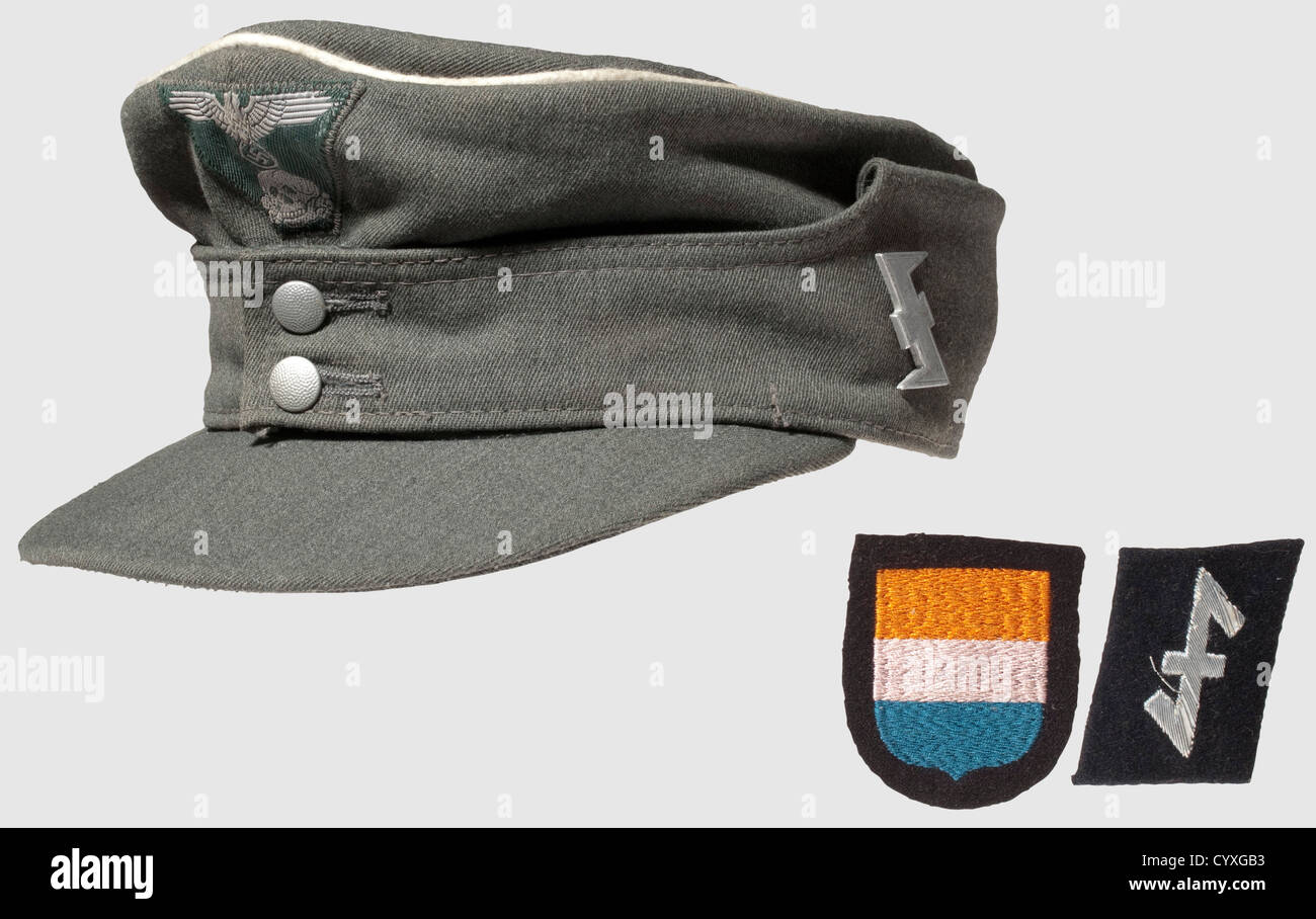 Eine Feldmütze M 43 und Abzeichen der Waffen-SS,für Führer der SS-Brigade 'Nederland' Mütze aus feinem italienischen Offizierstuch,durchgehende weiße Paspeln,zwei silberne Knöpfe.das 'bevo' Staatswappen in trapezförmiger Form,silbergraues Gewebe auf einem Feld grünen Hintergrund.ein Aluminium 'Wolfsangel' Abzeichen,das Erkennungswappen der niederländischen SS,ist mit zwei Pins befestigt Die linke Seite.Silbergrauer Innenfutter im Fischgrätenmuster mit der Größenbezeichnung '57' und einem naturfarbenen Stirnschweißband.Schwarz, rechter Kragenstreifen mit aluminiumbesticktem Wolfsangel wie wir,Additional-Rights-Clearences-nicht verfügbar Stockfoto