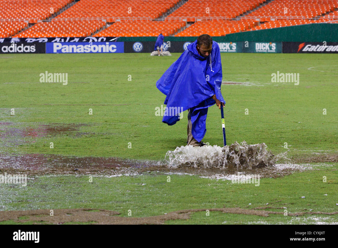 Ein Platzwart reinigt das Wasser außerhalb des Spielfelds nach ein schwerer Sturm eine Regen-Verzögerung von einem MLS-Match zwischen DC United und Houston verursacht Stockfoto