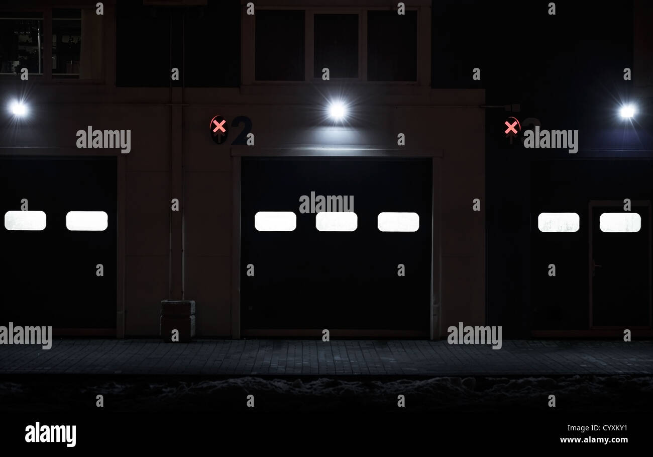 Nacht Hintergrundtextur von modernen Lagerhalle Wand mit geschlossenen Toren und Lichter Stockfoto