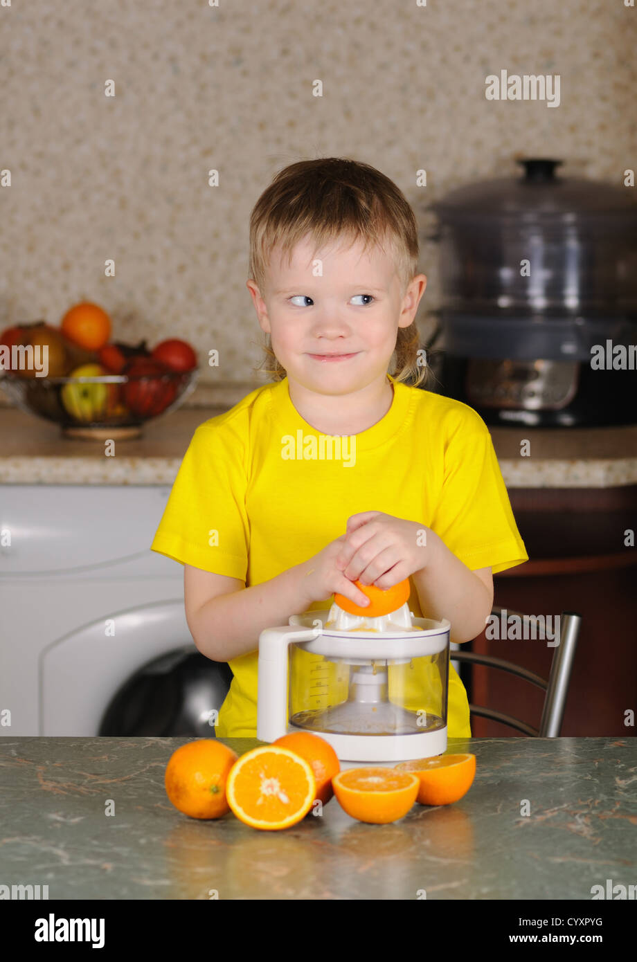 Das Kind in eine gelbe Weste, auswringen, Saft von einer orange Stockfoto