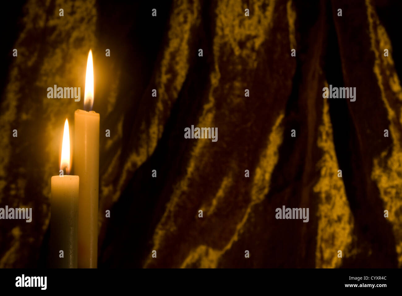 Zwei Kerzen aussteigen vor einem dunklen Hintergrund. Stockfoto