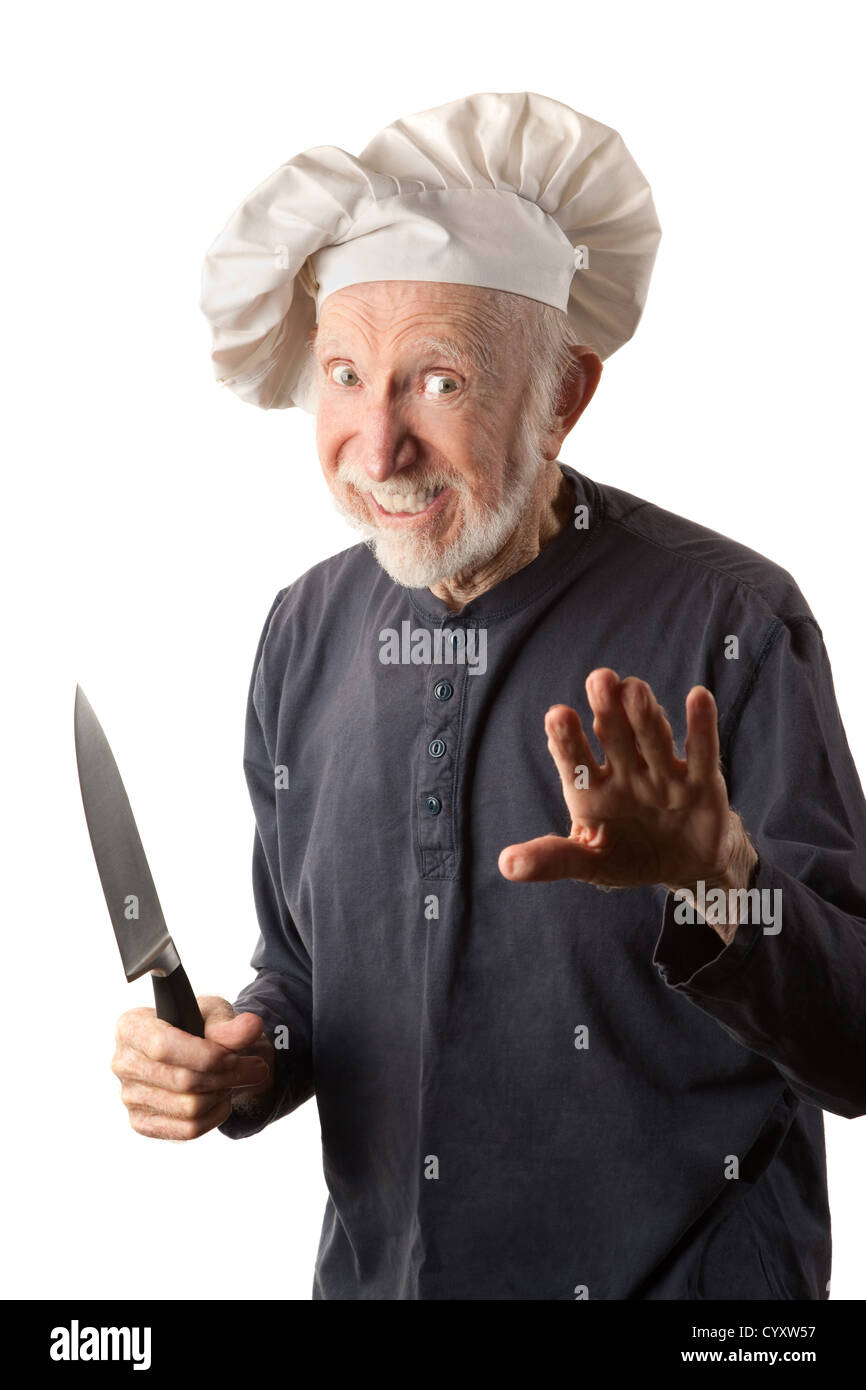 Lustige Seniorchef mit großen weißen Hut und Messer Stockfoto