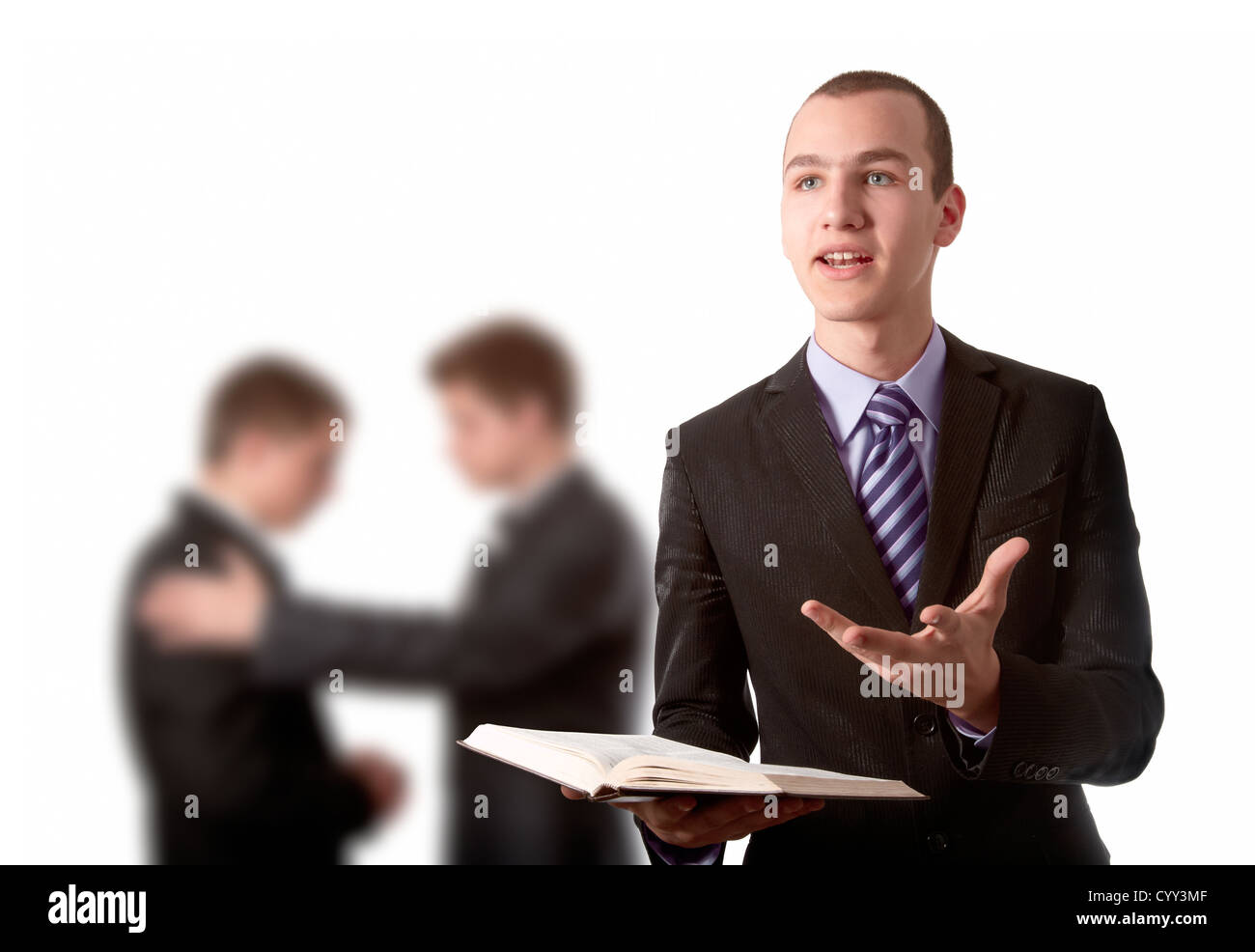 Junger Mann predigen das Evangelium und die beiden anderen beten im Hintergrund Stockfoto