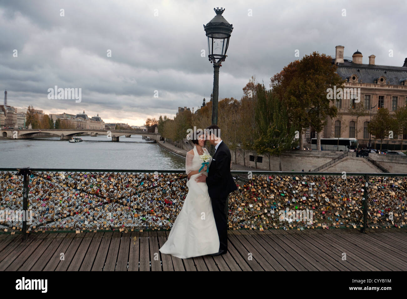 Besen und Braut auf Pont des Arts, wo Tausende von Paaren ein Vorhängeschloss auf dem Zaun als Beweis ihrer ewigen Liebe über den Fluss Seine, Paris verlassen haben Stockfoto