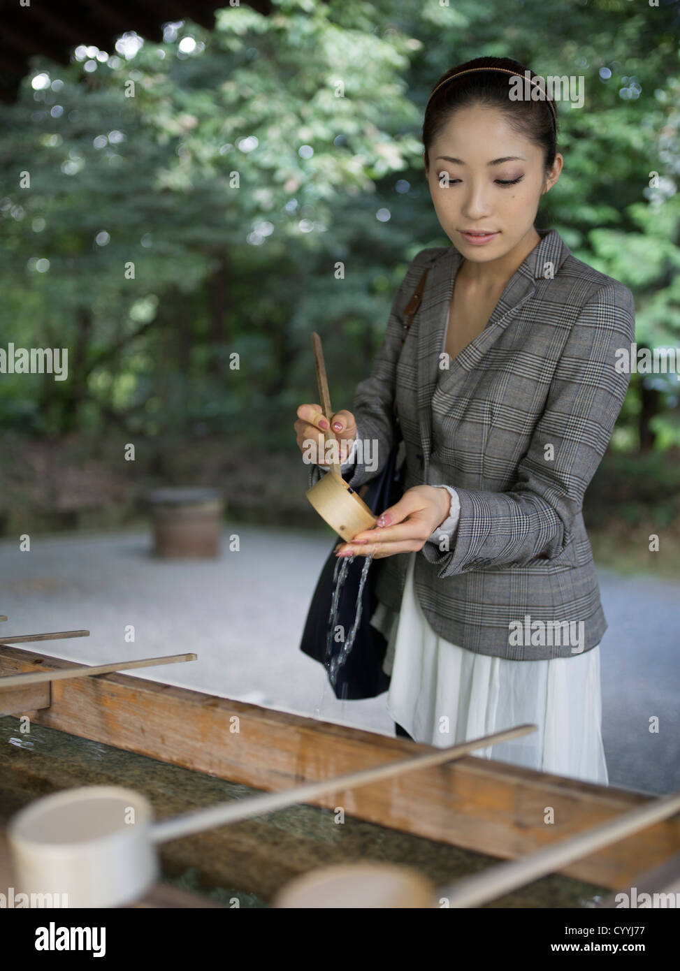 Schöne junge Japanerin Meiji-Jingu Schrein, Tokyo zu besuchen. Bei der Reinigung-Trog (Chōzuya oder Temizuya) Stockfoto
