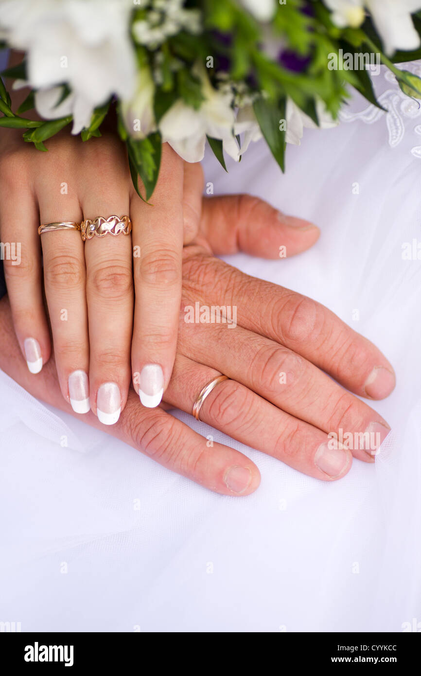 Händen der neuen verheiratet mit goldenen Ringen und Blumenstrauß Stockfoto