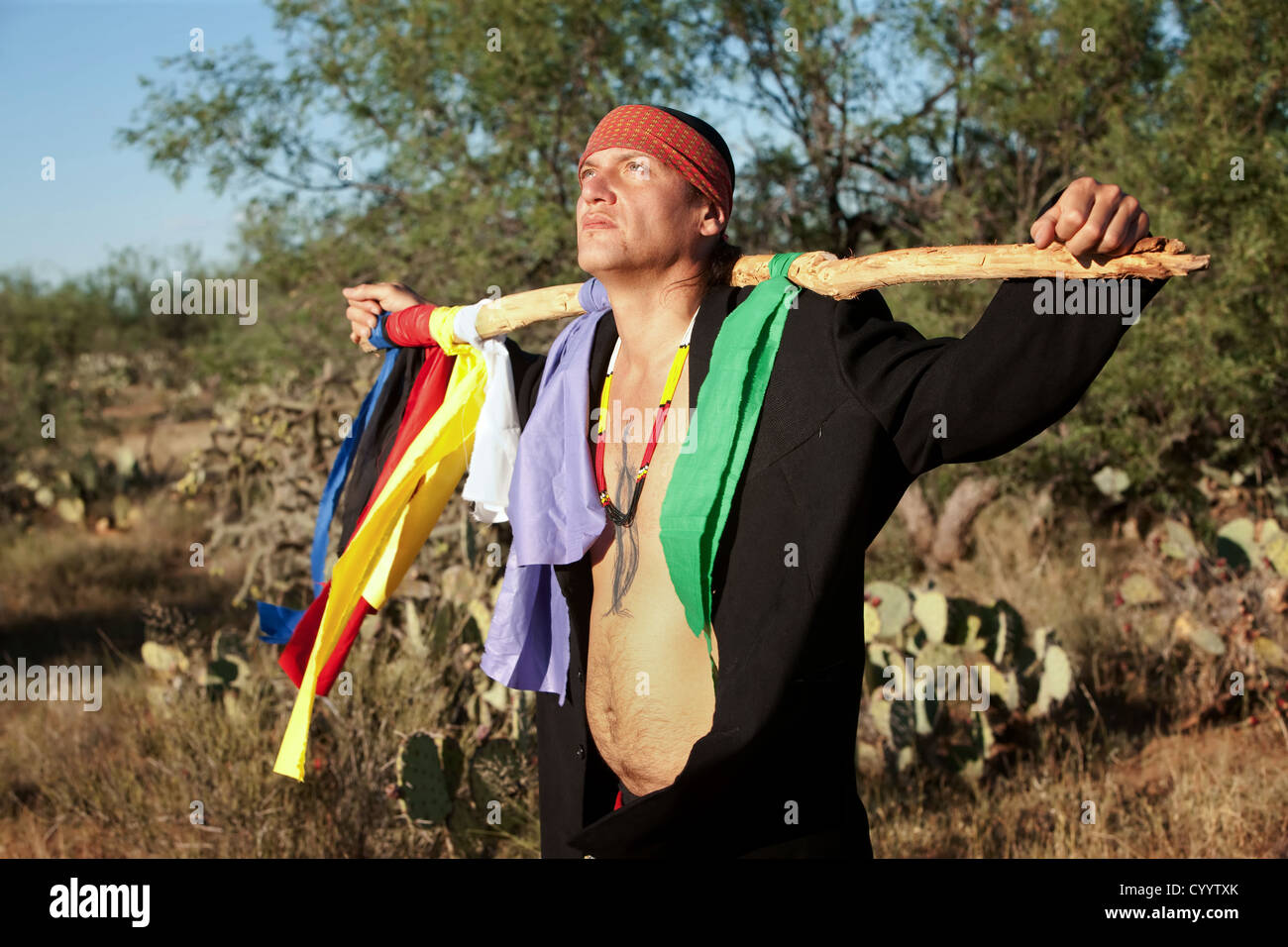 Gebürtige amerikanischer Mann mit bunten Fahnen repräsentieren sieben Richtungen Stockfoto