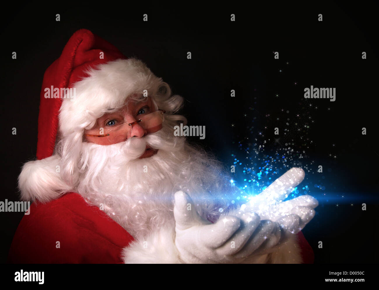 Thema Weihnachten mit dem Weihnachtsmann magische Lichter in den Händen halten Stockfoto
