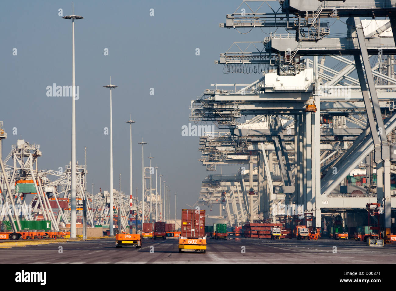 Hafenkräne und Roboter-LKW mit Containern in einem großen Hafen. Stockfoto