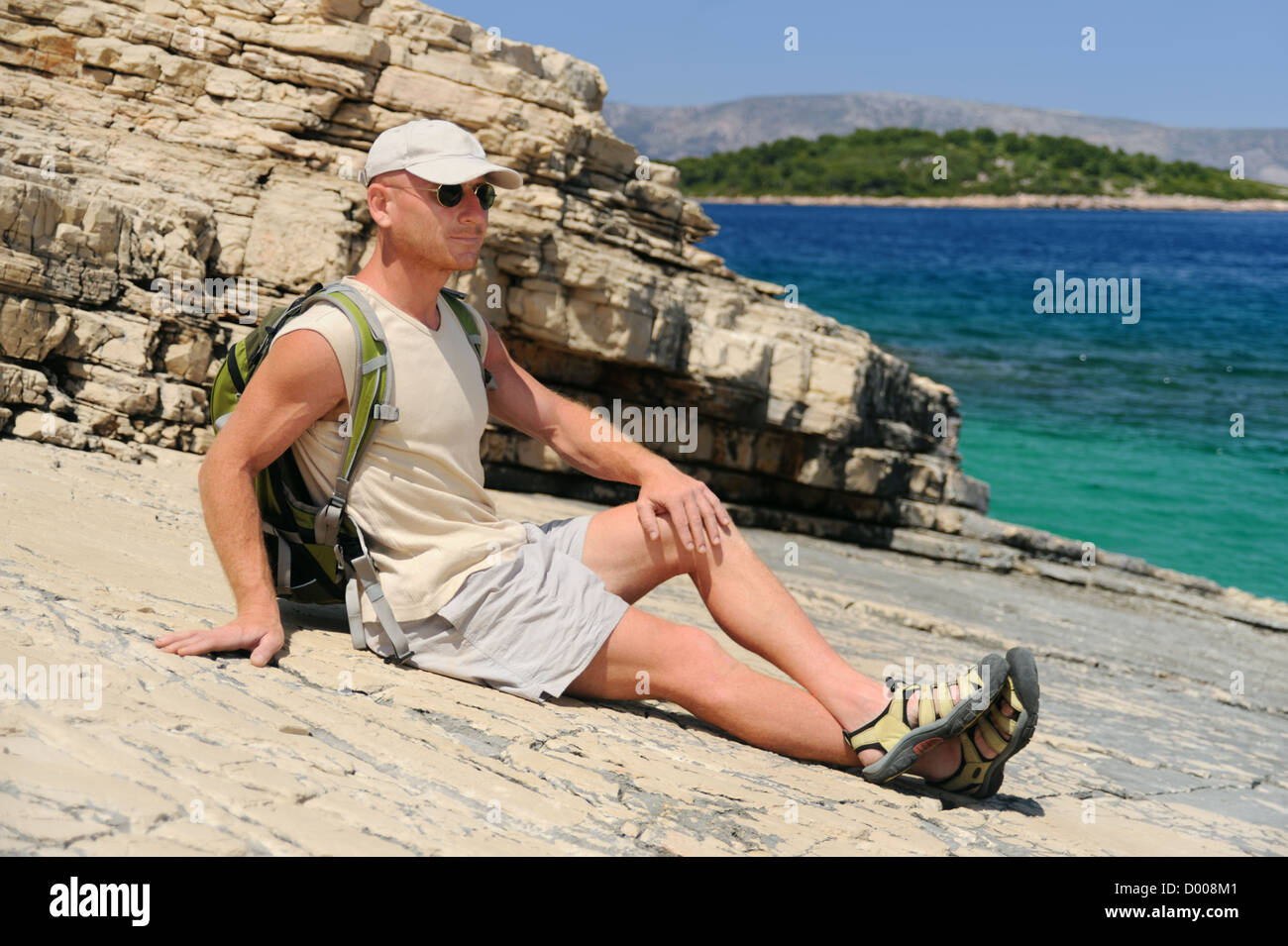 Outdoor-Mann ruht auf Felsen nach dem Wandern, Kroatien Stockfoto