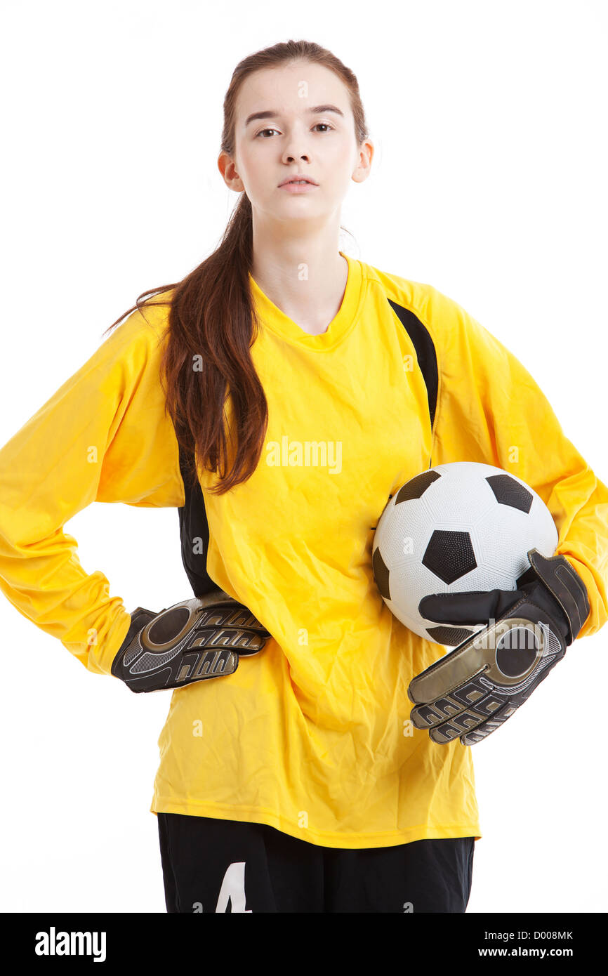 Porträt der jungen weiblichen Fußballspieler mit Ball mit der Hand auf Hüfte vor weißem Hintergrund Stockfoto