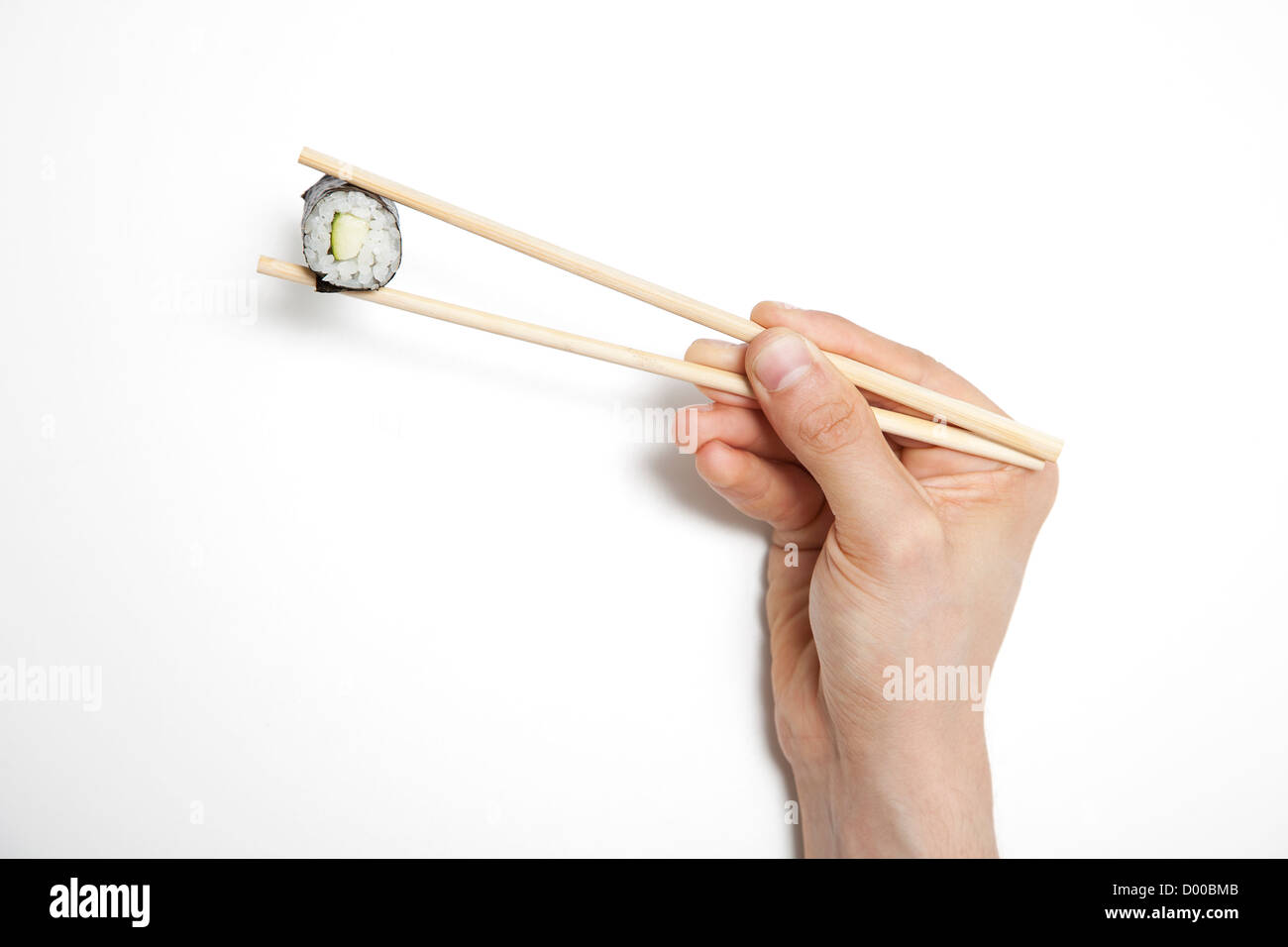Mannes Hand Holding Sushi Rollen in Stäbchen vor weißem Hintergrund Stockfoto