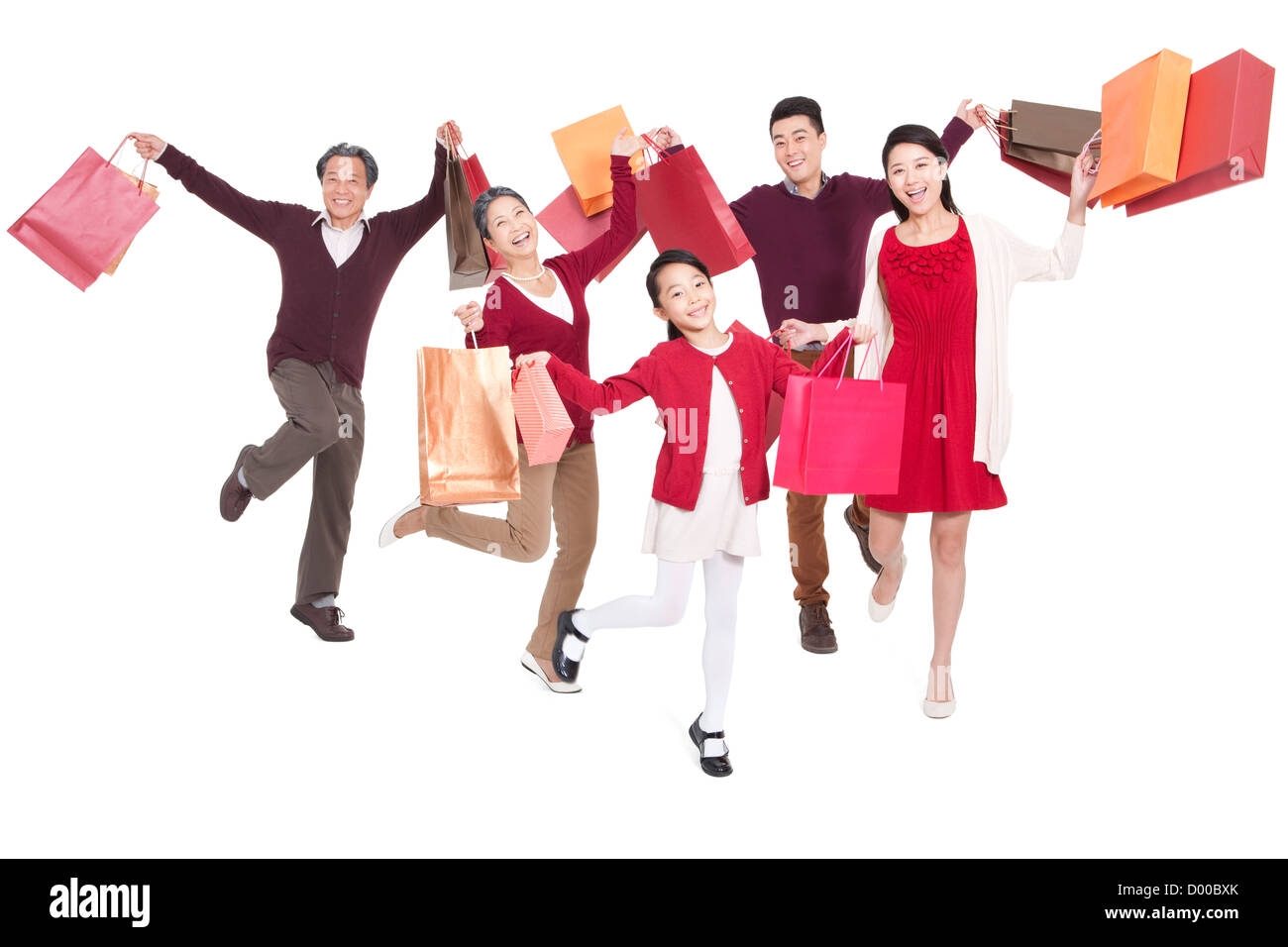 Fröhliche Familie springen in der Luft mit Einkaufstüten Stockfoto