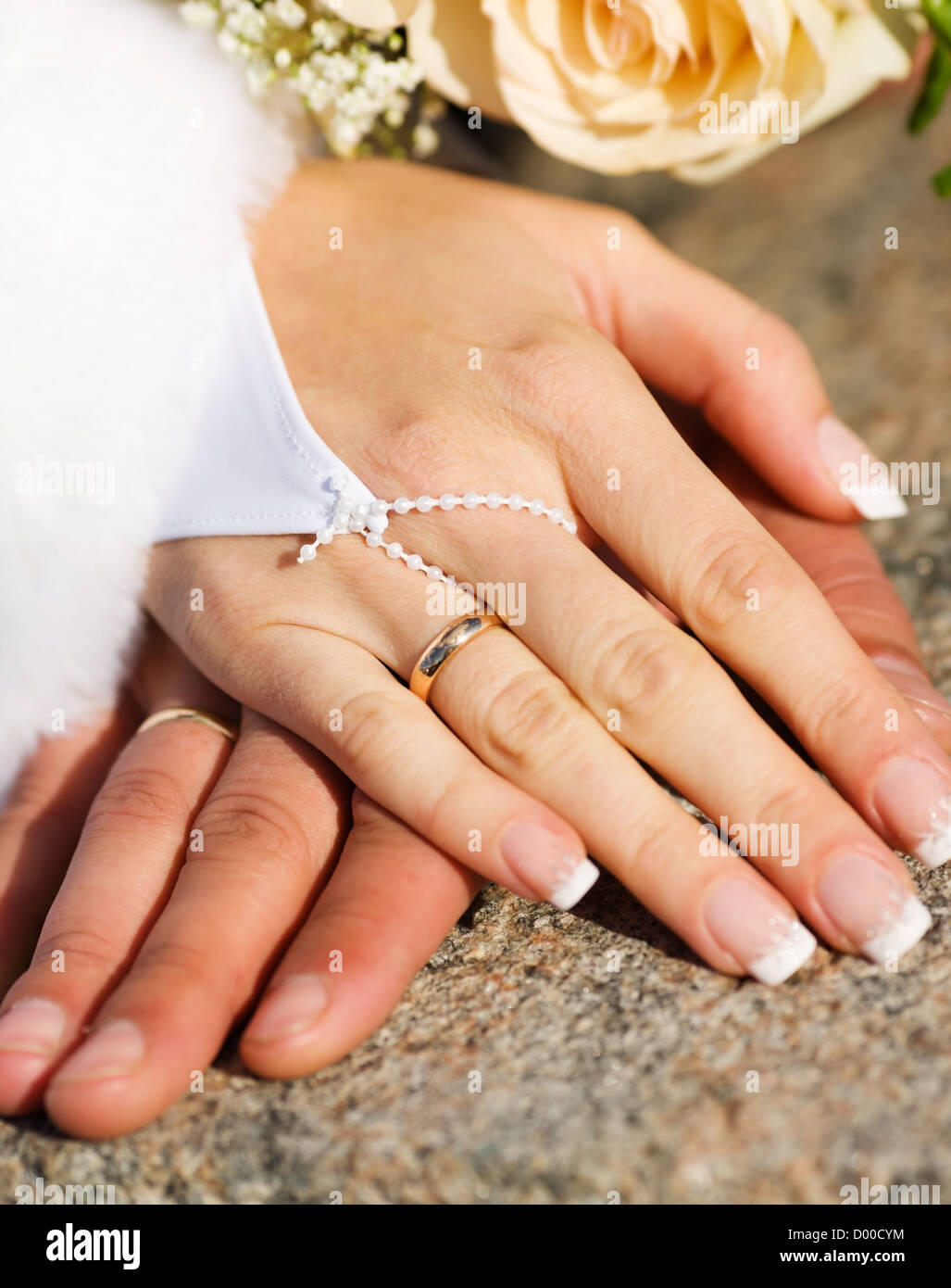Händen der neuen verheiratet mit goldenen Ringen und Blumenstrauß Stockfoto