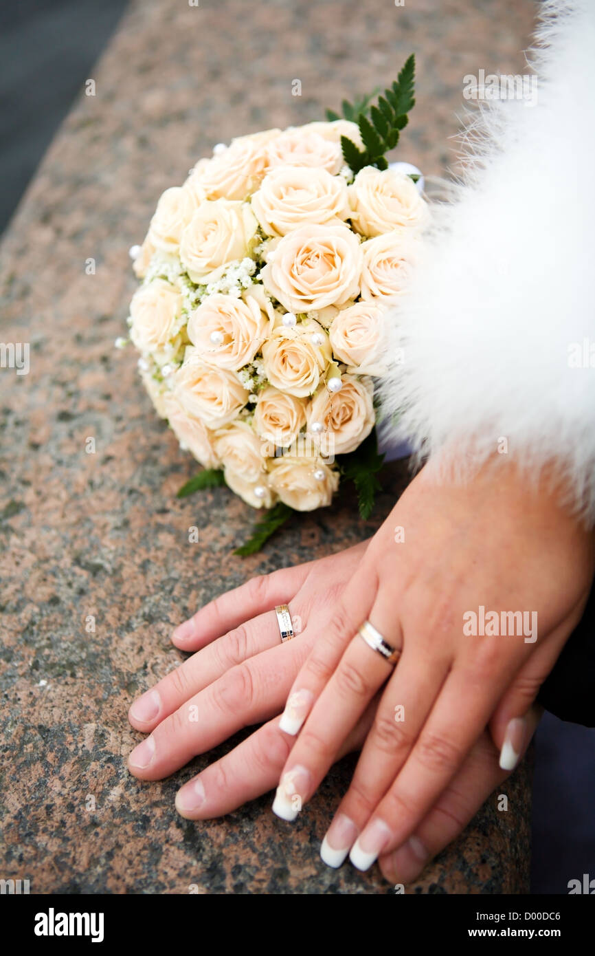 Händen der neuen verheiratet mit goldenen Ringen und Blumenstrauß Stockfoto