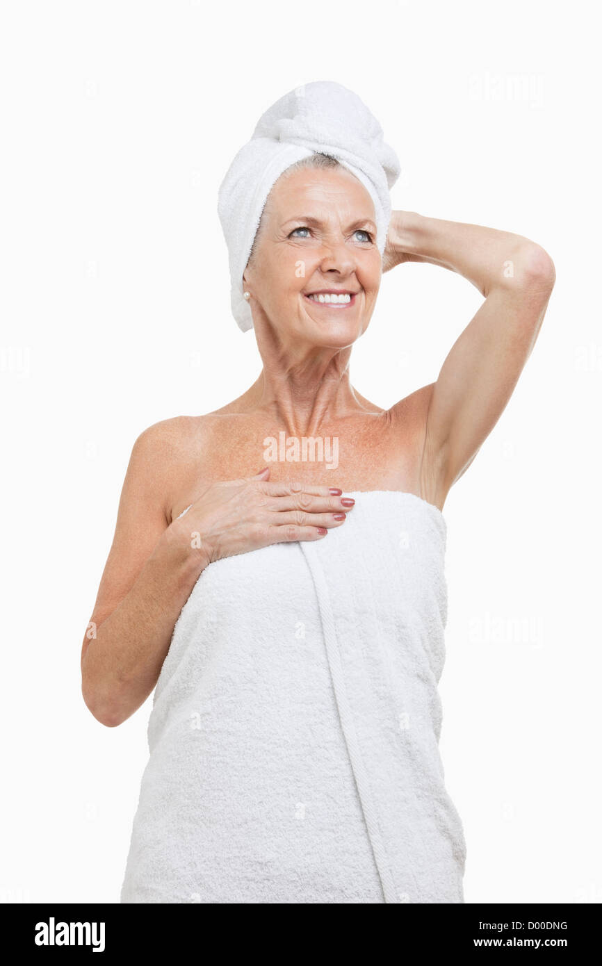 Ältere Frau eingewickelt in Tücher vor weißem Hintergrund Stockfoto