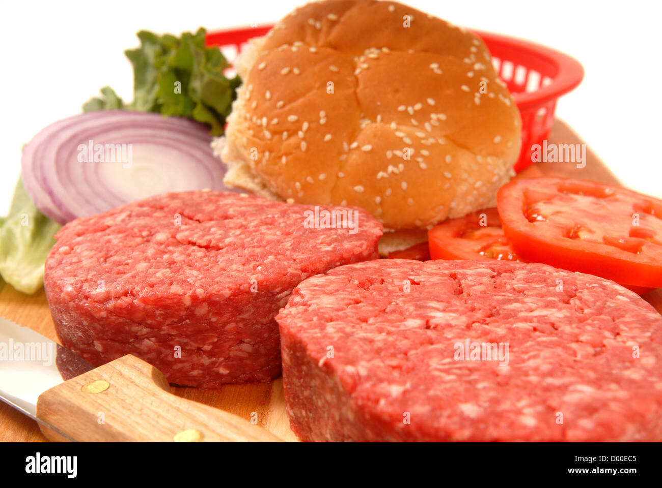 Picknick-Zutaten für Cheeseburger einschließlich Pasteten, Tomaten, Zwiebeln und Salat Stockfoto