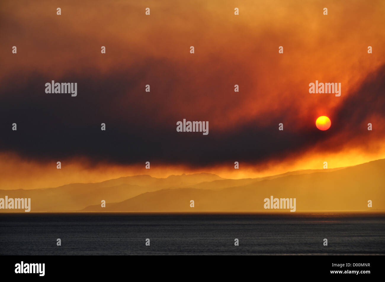 Sonnenaufgang und ein Lauffeuer Rauchen, Sizilien, Italien Stockfoto