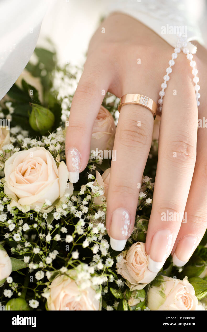 Hand der Braut mit goldenen Ring und bouquet Stockfoto
