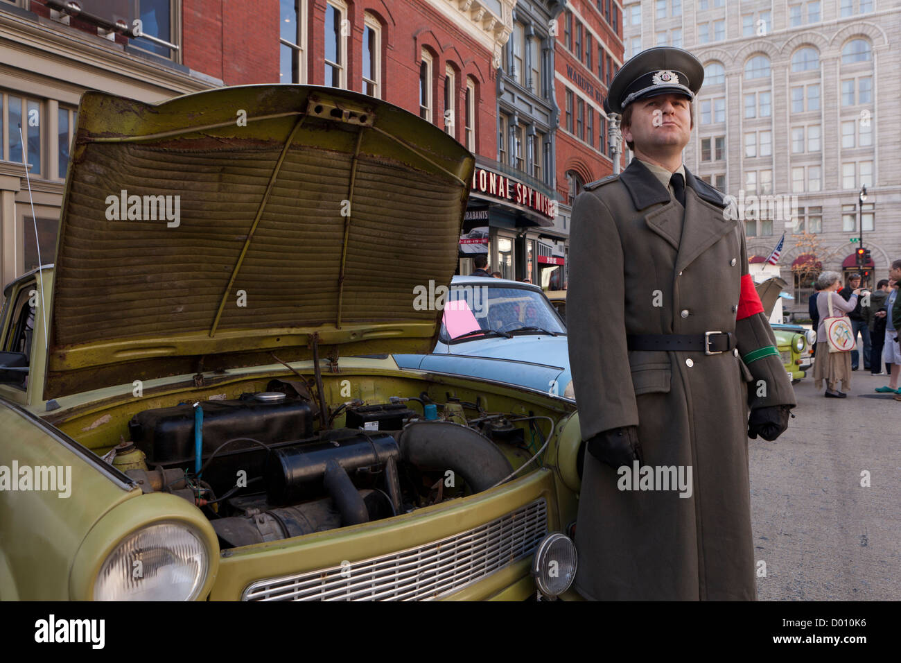 DDR-Stasi Offizier Reenactor stehen neben 60er Jahre DDR 2-Takt-Motor Auto Trabant Stockfoto