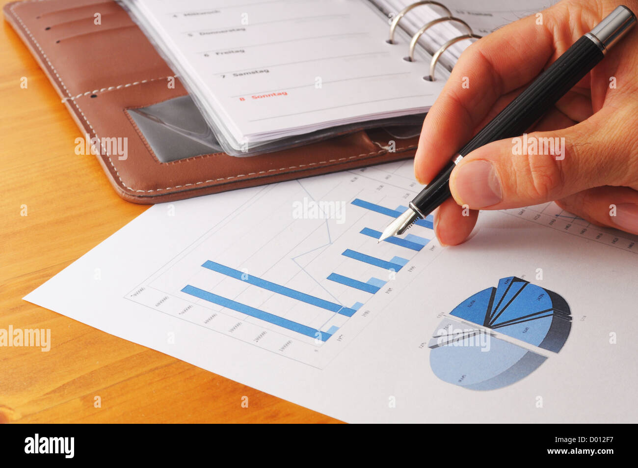 Hand und Papierkram mit Unternehmensinformationen und Stift Stockfoto