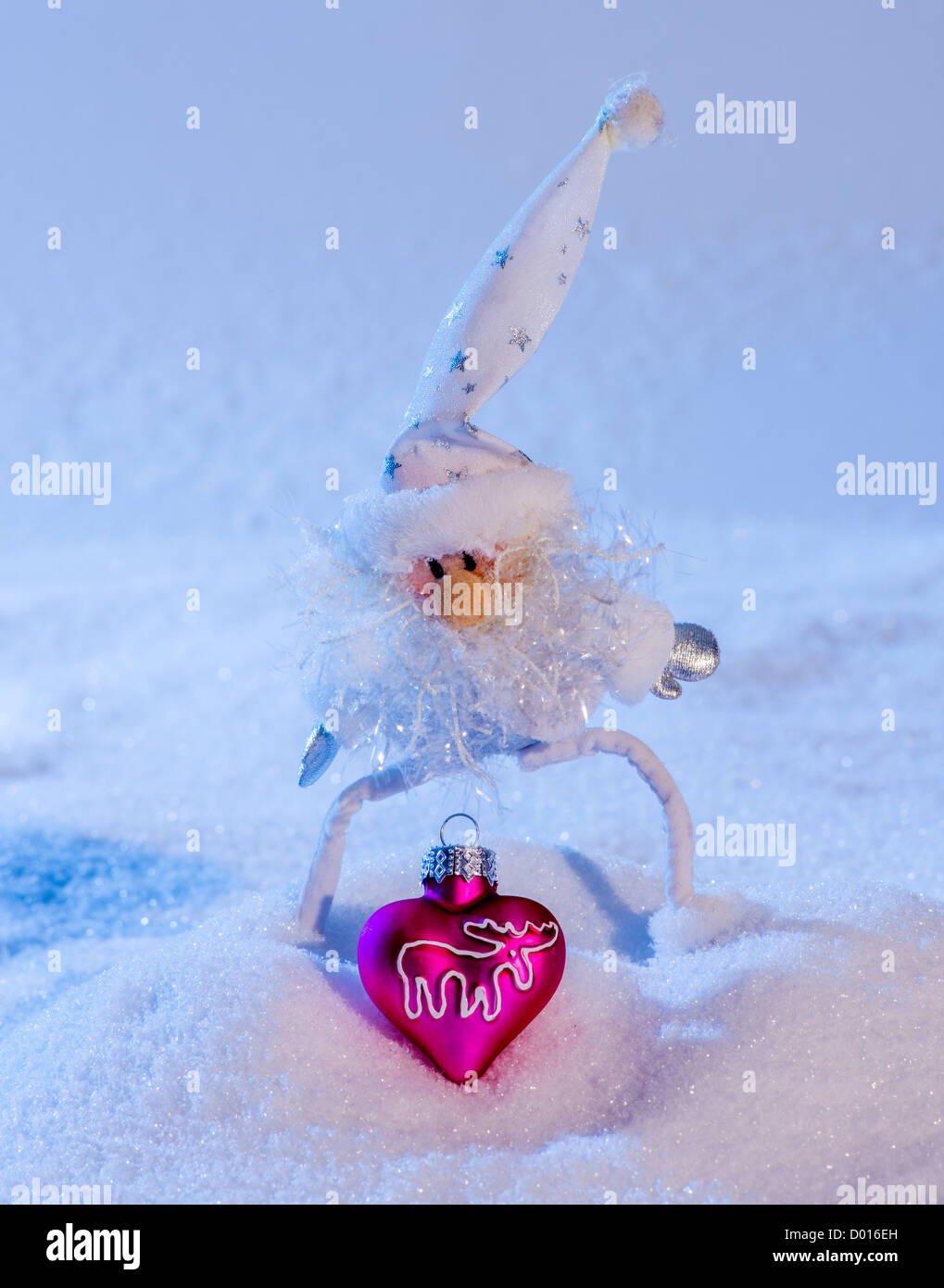 Santa Claus in der Liebe. Herzförmige Weihnachtskugel auf Schnee. Stockfoto
