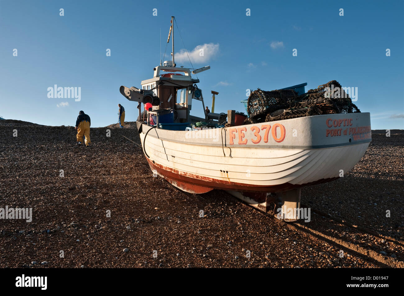 Ein kleines Fischerboot, das mit Hummertöpfen beladen ist und am Kiesstrand von Deal, Kent, Großbritannien, hinaufgezogen wird Stockfoto