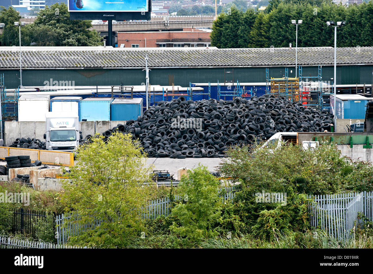 Alte Gebrauchte Autoreifen Reifen gestapelt auf einem Gewerbegebiet warten recycling in neue Produkte. Stockfoto