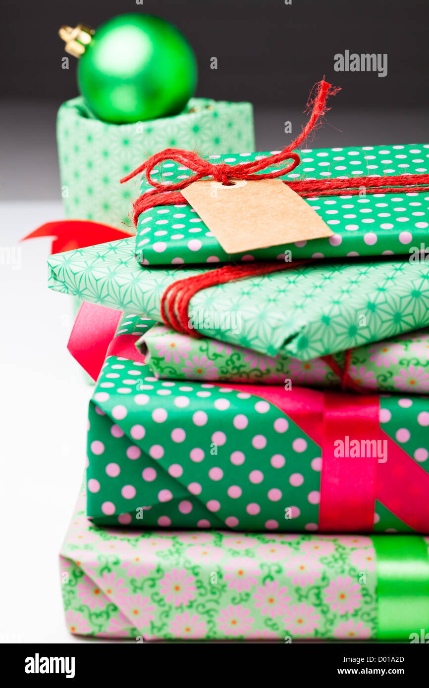 Verpackte Weihnachtsgeschenke mit leeren Tag und Christbaumkugel Dekorationen Stockfoto