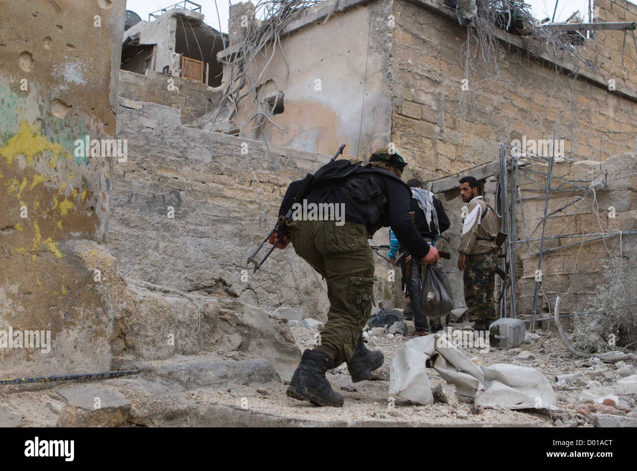 25. Oktober 2012 - Aleppo, Syrien: Freie Syrische Armee Mitglieder führen vorbei an Scharfschützen Ausblick in Safa. Stockfoto