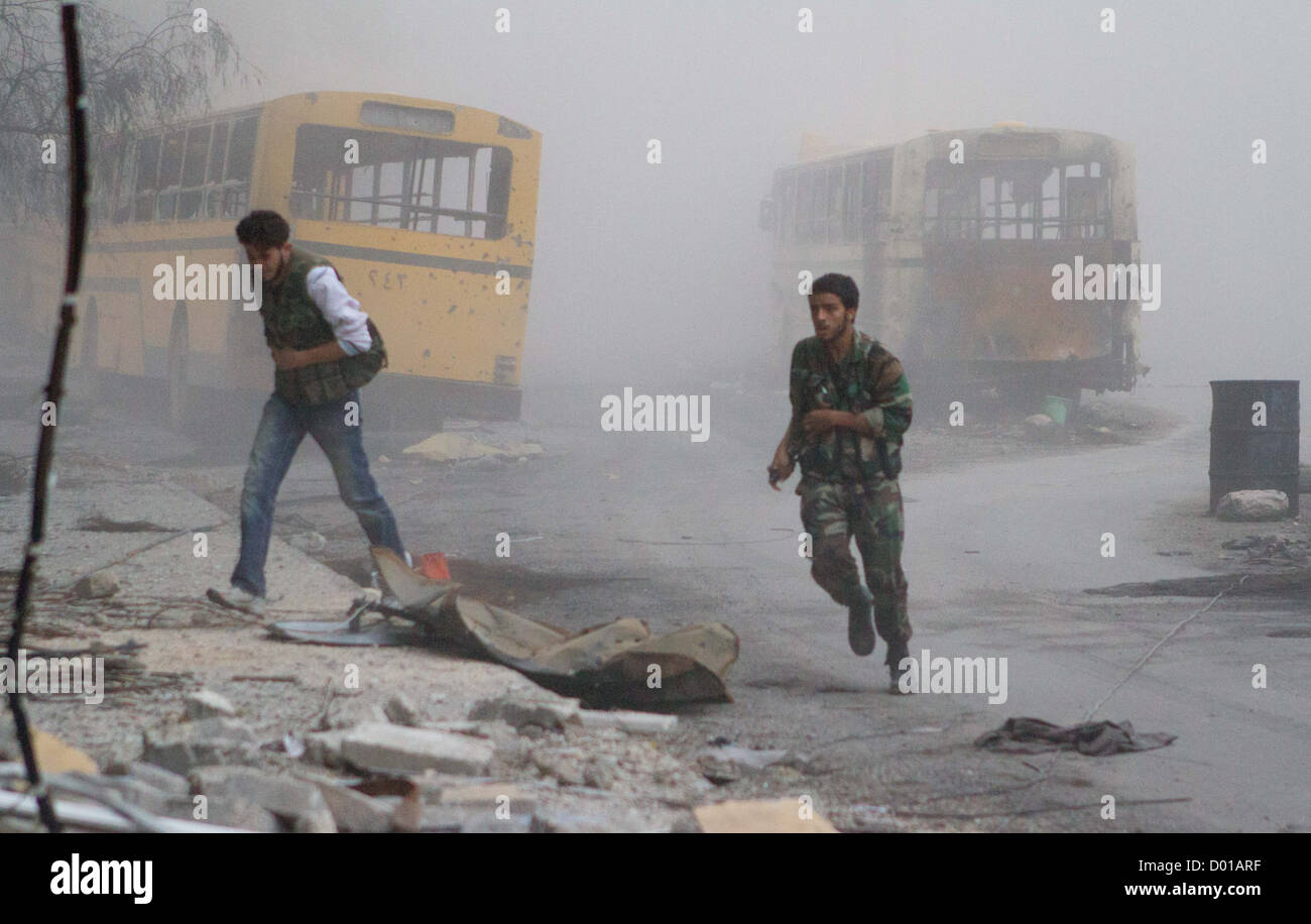 23. Oktober 2012 - Aleppo, Syrien: Freie Syrische Armee Mitglieder nehmen Deckel nach einem Panzerangriff in den Straßen von Bustan Al Basha. Stockfoto