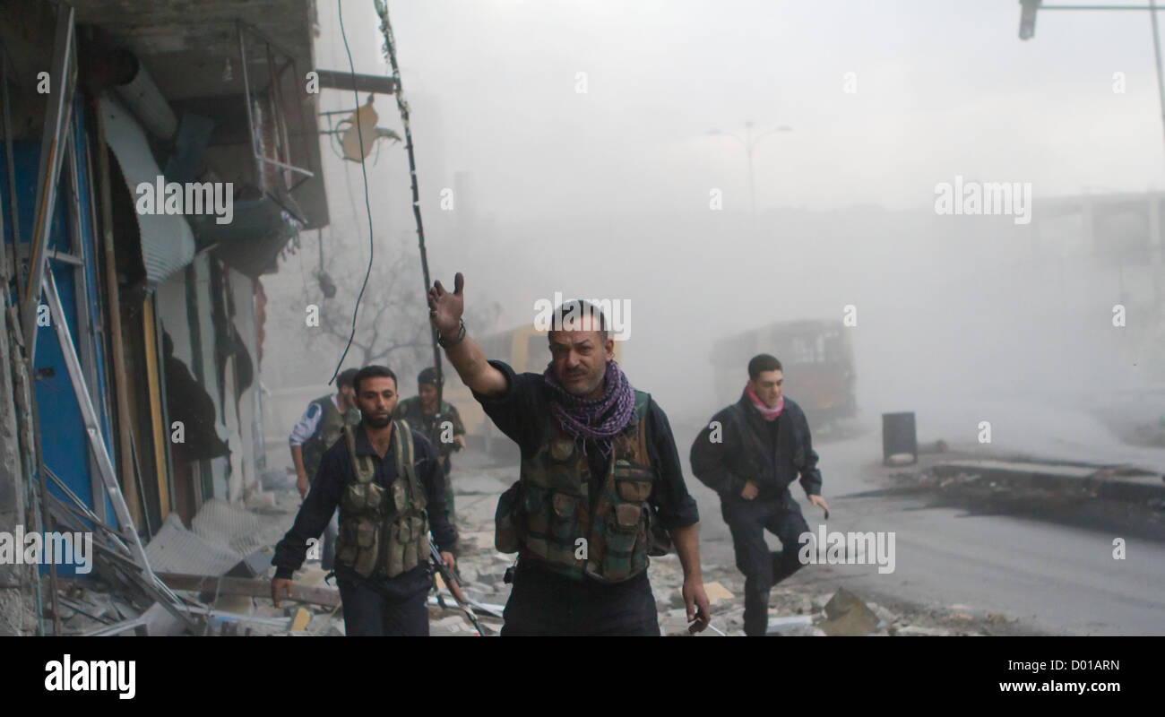 23. Oktober 2012 - Aleppo, Syrien: Freie Syrische Armee Mitglieder nehmen Deckel nach einem Panzerangriff in den Straßen von Bustan Al Basha. Stockfoto