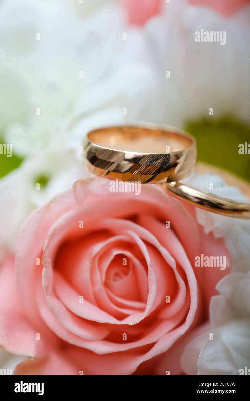 Zwei goldene Hochzeit Ringe auf Blüten Makroaufnahme Stockfoto