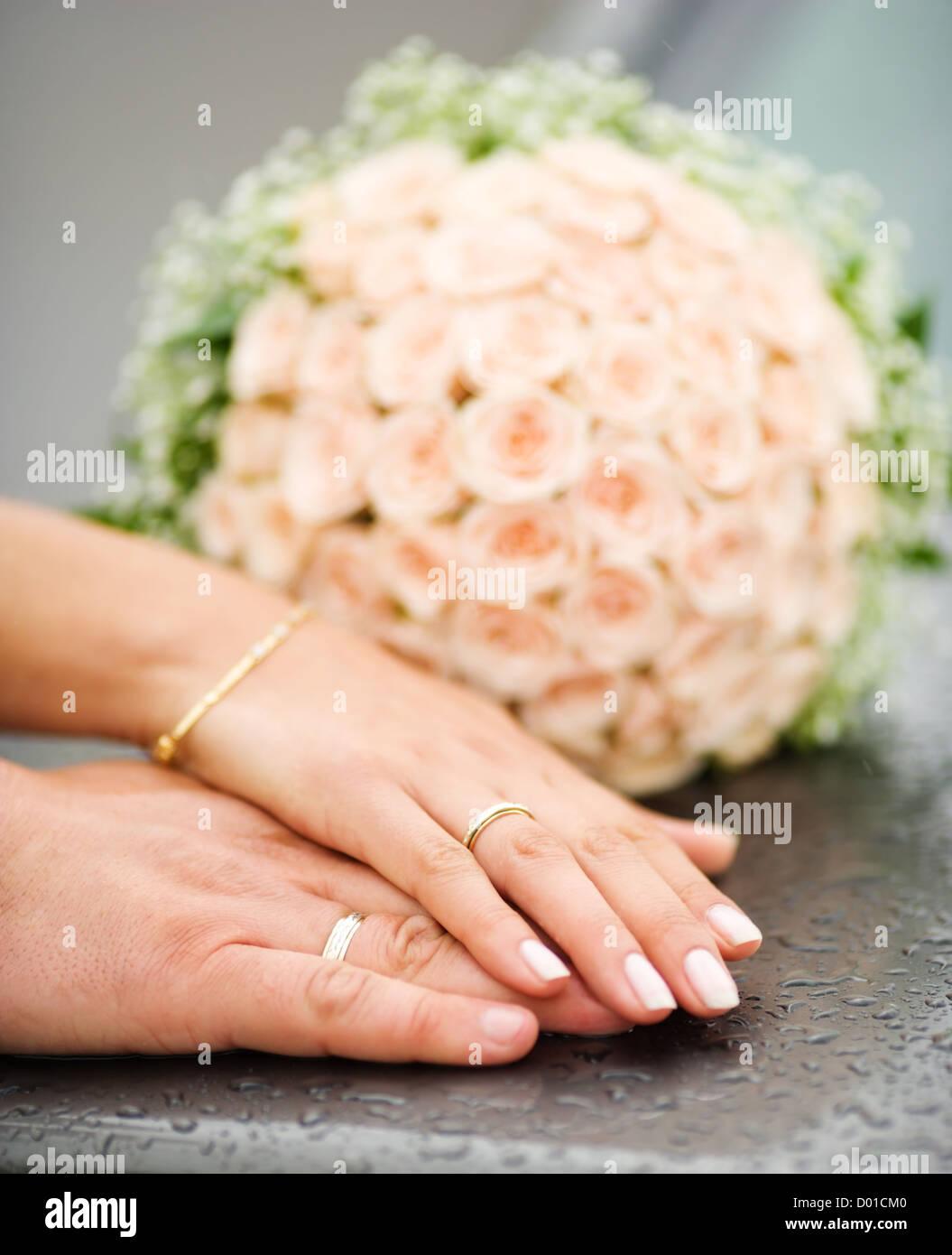 Händen der neuen verheiratet mit goldenen Ringen und Blumenstrauß Stockfoto