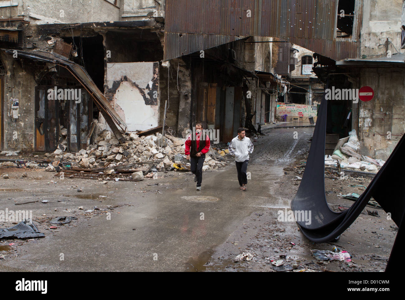 22. Oktober 2012 - Aleppo, Syrien: Zwei Männer führen vorbei an einem Scharfschützen in der Altstadt. Stockfoto