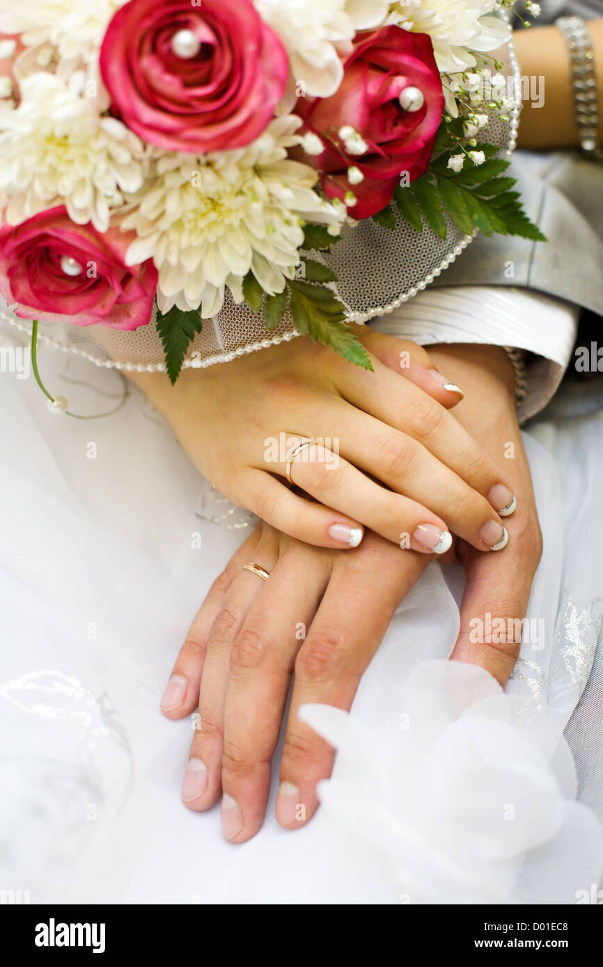 Händen der neuen verheiratet mit goldenen Ringen und Blumenstrauß Stockfoto