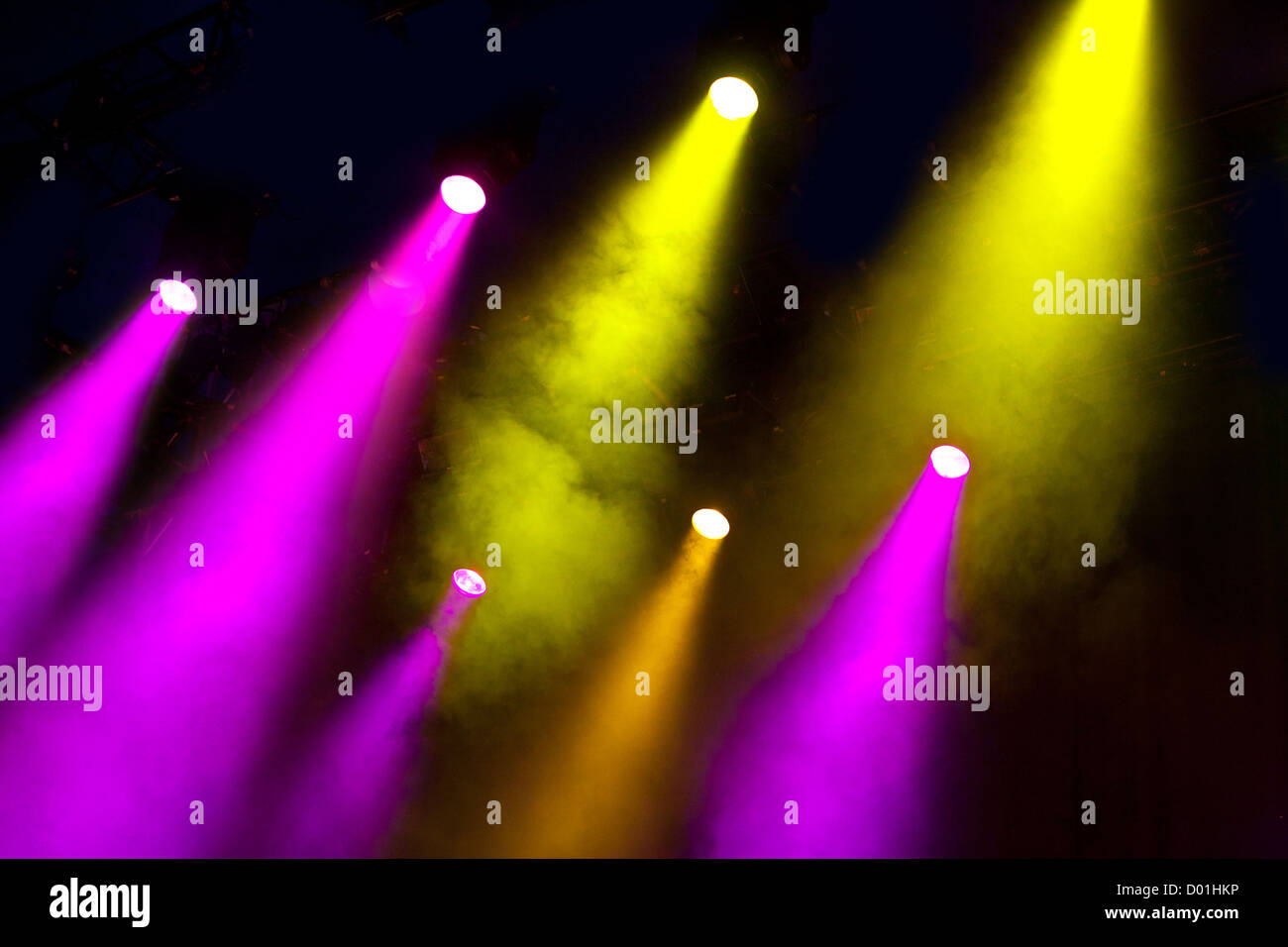 Wellen von farbigen Farblicht glänzen durch atmosphärische Rauch auf dramatische Weise auf eine leere Bühne Licht Stockfoto
