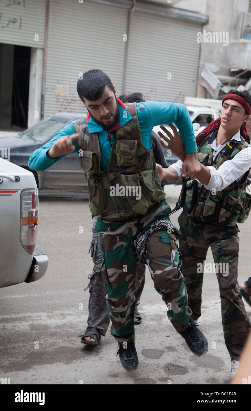 22. Oktober 2012 - Aleppo, Syrien: Freie Syrische Armee Kämpfer Hilfe verletzte Männer in ein Krankenhaus, frontline. Stockfoto