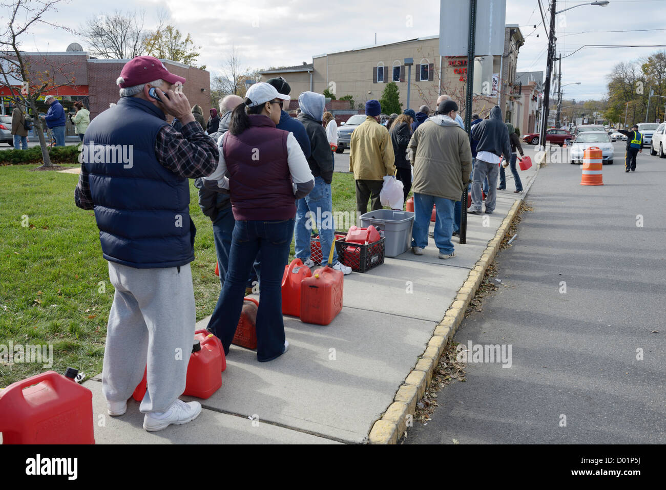 Linie an Tankstelle nach Hurrikan Sandy, northern NJ.  Menschen mit Dosen, die darauf warten, Gas für Autos und Generatoren zu erhalten. Stockfoto