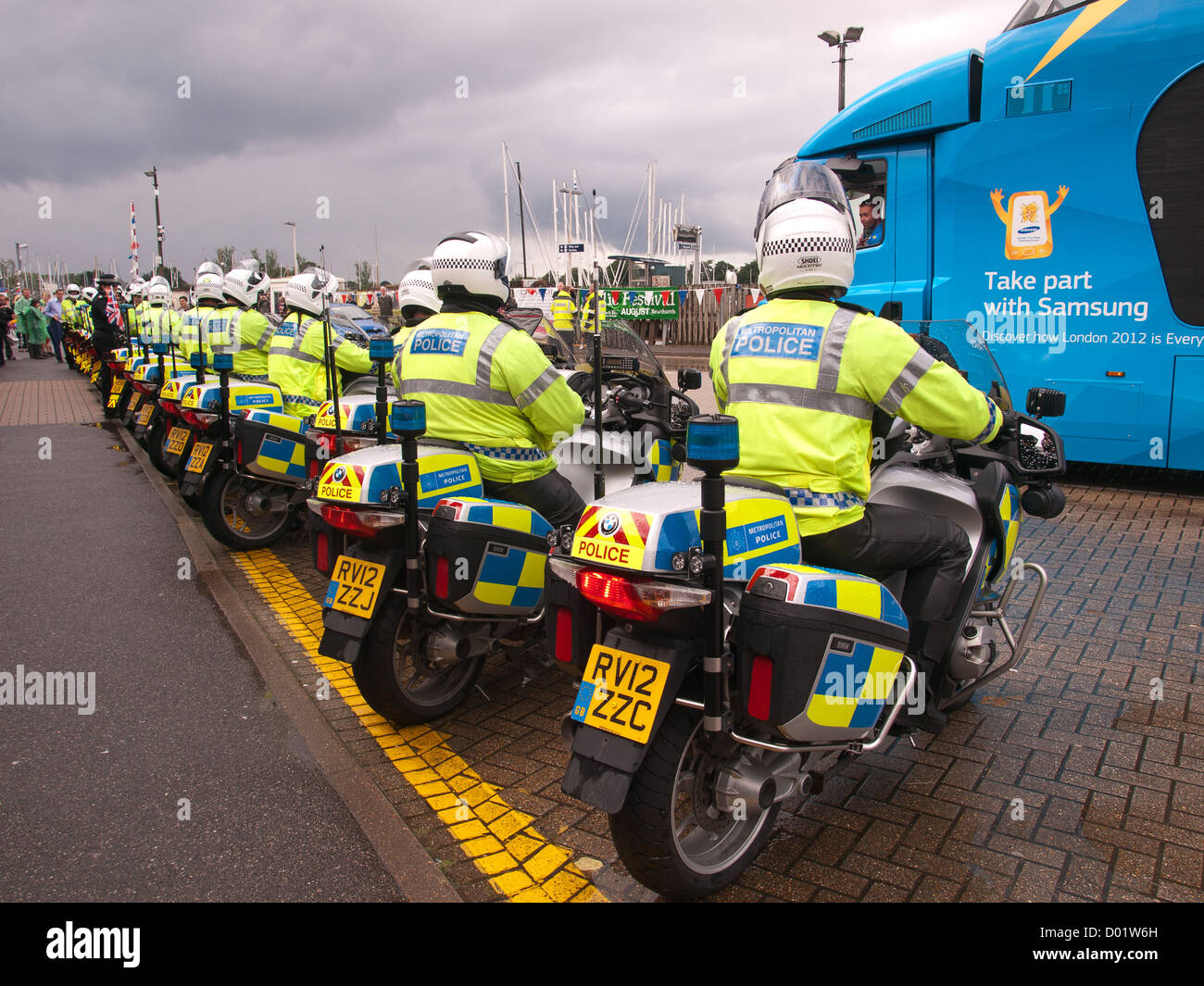 Olympischer Fackellauf Lymington Hampshire England UK - Polizei Fahrräder warten auf Laufwerk auf die Autofähre Wightlink Stockfoto