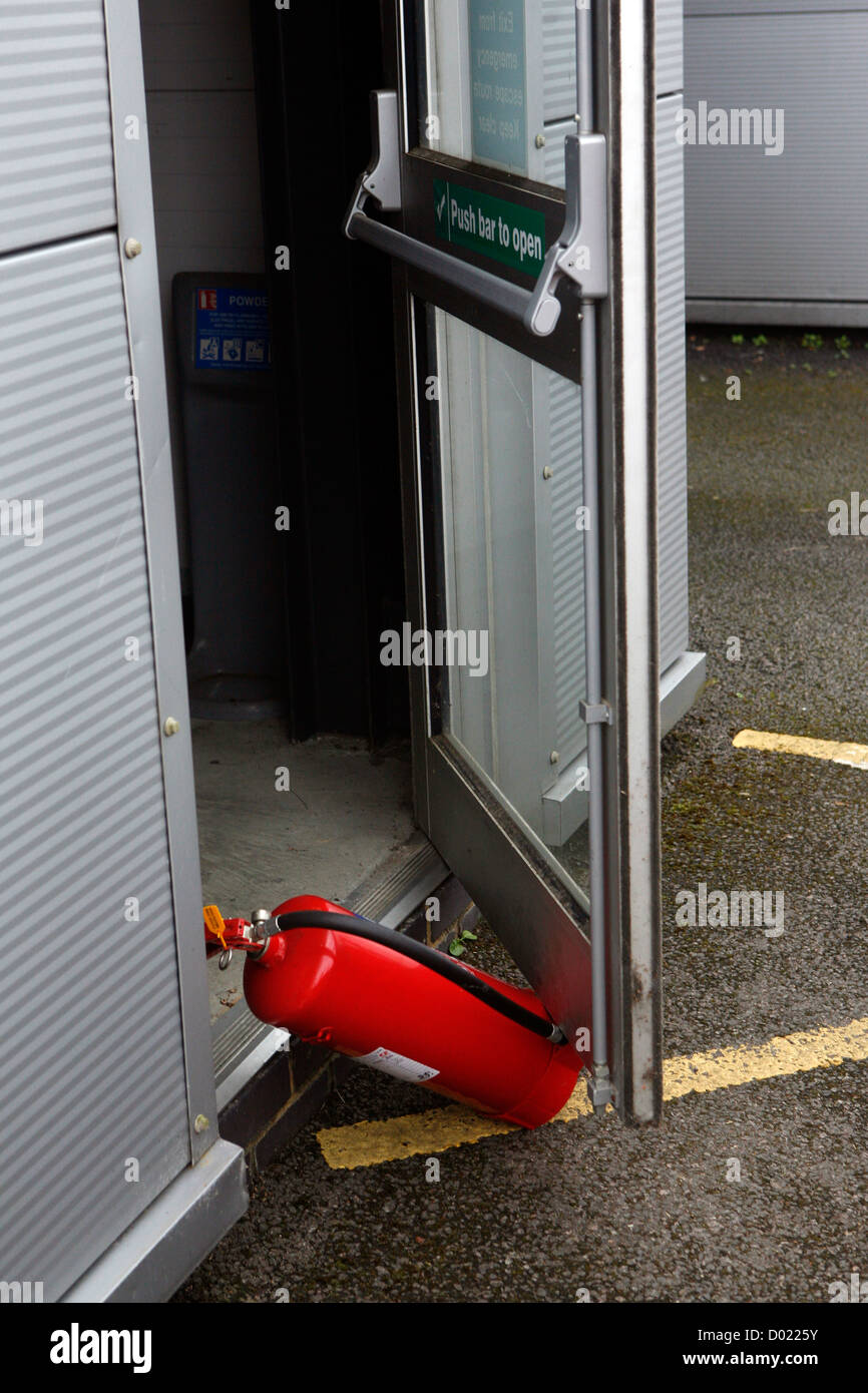 Ein Feuerlöscher verwendet wird, um zu stützen öffnen eine Bürotür. Stockfoto